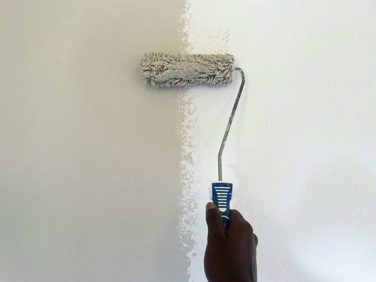 Illustrative trade photograph of a roller applying a fresh coat of wall paint
