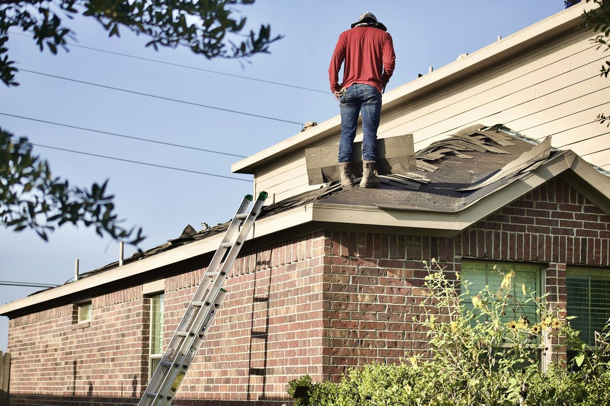 Illustrative trade photograph of a worker repairing a residential roof